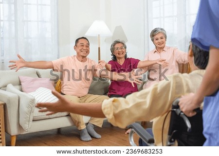Selective focus on elderly people raising hands to hug friend who sitting on wheelchair to encourage, fighting with disease, smiling with happiness, sitting in nursing home. Retirement Concept
