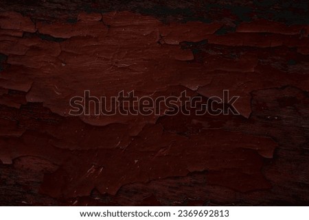 Dark texture of painted wood in red color. Close-up.