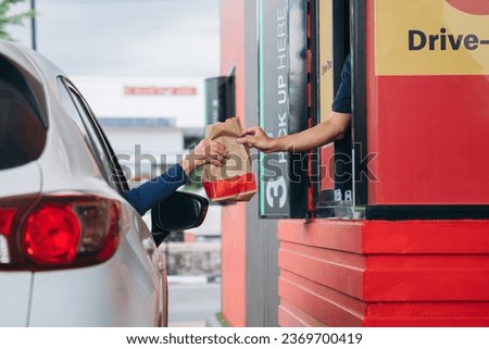 Young Man receiving coffee at drive thru counter., Drive thru and take away for protect covid19. Royalty-Free Stock Photo #2369700419