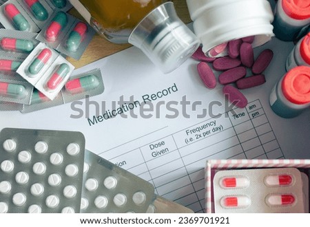 A patient's daily routine managing multiple medications. The central focus is on a medication schedule chart surrounded by an array of different medicines. Selective focus.
 Royalty-Free Stock Photo #2369701921