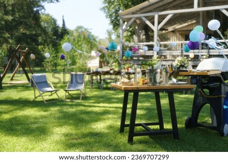 Summer garden party in a beautiful garden with a large wooden deck in the background.