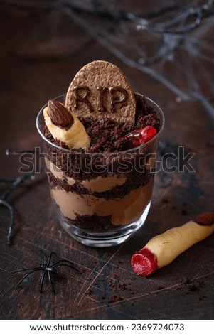 Sweet and funny  desserts for Halloween party. Dirt graveyard chocolate triffle with  Witch Finger cookies and gummy worms