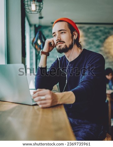 thoughtful man sitting in cafeteria and feeling pondering on music song Royalty-Free Stock Photo #2369735961