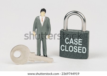 Business concept. On a white surface there is a figurine of a businessman, a key and a lock with the inscription - Case Closed