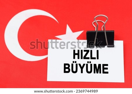 Economy and finance concept. On the flag of Turkey lies a business card with the inscription - rapid growth. Text in Turkish.