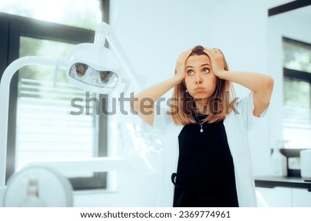 
Exasperated Stressed Dentist Feeling Concerned Standing in her Cabinet. Dental care worker being frustrated with overtime schedule 
 Royalty-Free Stock Photo #2369774961