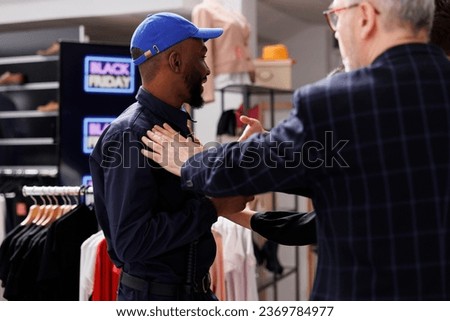 Security officer calming Black Friday crowd at store entrance. Rude people shoppers pushing police officer while waiting in line for sales, customers being disrespectful to retail workers Royalty-Free Stock Photo #2369784977