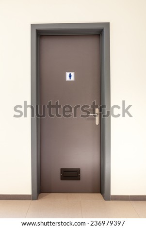 Womans restroom in an public building in Brown door.