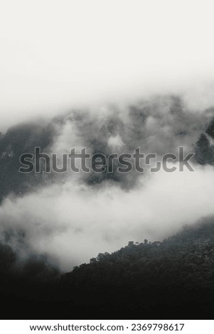 This picture is a natural landscape photo with mountains, clouds, and trees used as an illustration and background image.