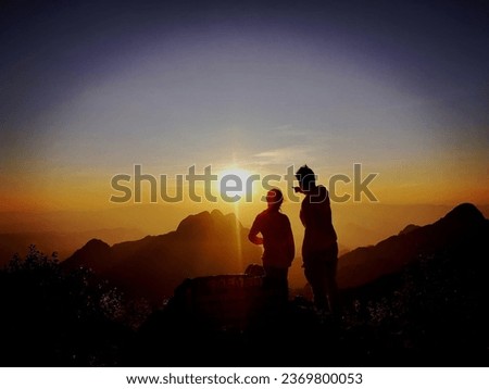This picture is a photograph of a natural view of mountains with clouds and a misty sky with golden sunlight shining down on the horizon, used as an illustration and background image.