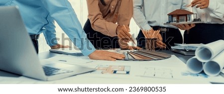 Group of interior designer team in meeting, discussing with engineer on interior design and planning for house project blueprint and model, choosing color sample and mood board materials. Insight