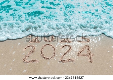 Message Year 2023 replaced by 2024 written on beach sand background. Good bye 2023 hello to 2024 happy New Year coming concept. Royalty-Free Stock Photo #2369816627