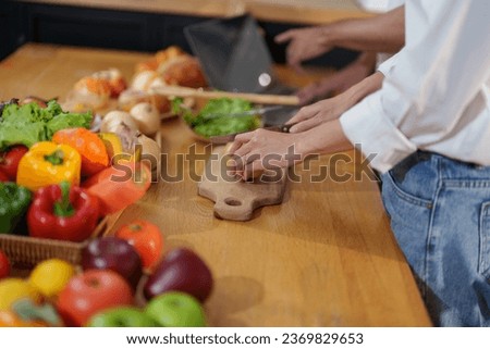 Couple cutting potatoes to cook or make salad in home kitchen