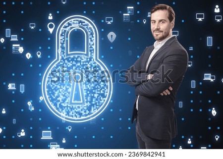 Attractive young caucasian businessman with folded arms looking at creative digital padlock hologram and pixel icons on blurry blue background. Secure, safety and technology concept