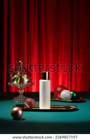 Scene for advertising product with christmas concept. An empty label bottle on golden tray decorated with sparkling pearls on red velvet fabric background. Front view, space for design