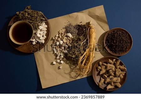Ginseng roots, dried mint leaves, Lavender and Sand ginger are featured on a paper. Other medicine with a bowl of tonic displayed around