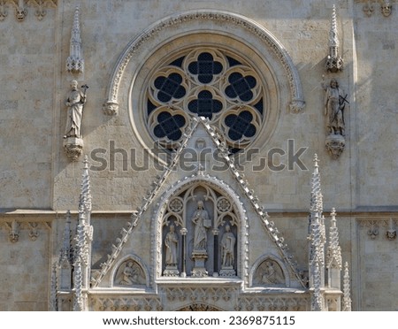 Close-up photo of a Gable triangle with a statue of Christ the teacher, above the main entrance to the Zagreb Cathedral in Croatia