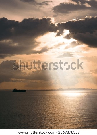 ship in the ocean with an evening sky and rays of light coming through the clouds  Royalty-Free Stock Photo #2369878359
