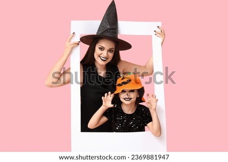 Little girl and her mother dressed for Halloween with frame on pink background