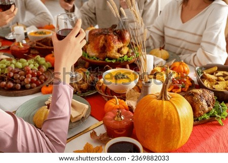 Young woman having dinner with her friends at festive table on Thanksgiving Day, closeup