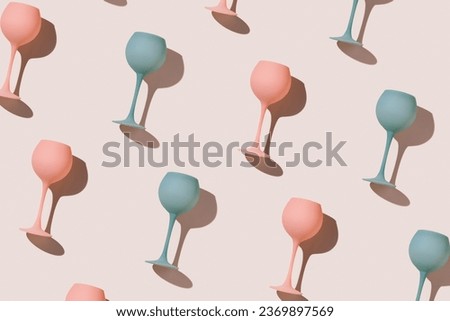 Minimal trend pattern from pink and blue colored wine glasses on beige background, geometric stylish layout of goblets. Entertainment, event, summer party concept. Abstract alcohol drinks flat lay