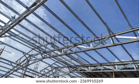 Metal structure of the warehouse againts the sky. Frame roof of warehouse. Royalty-Free Stock Photo #2369910269