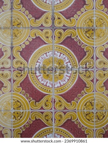 Part of a typical Portuguese wall decorated with tiles. Nice yellow, white and pink colors. Portugal. Vertical photo.