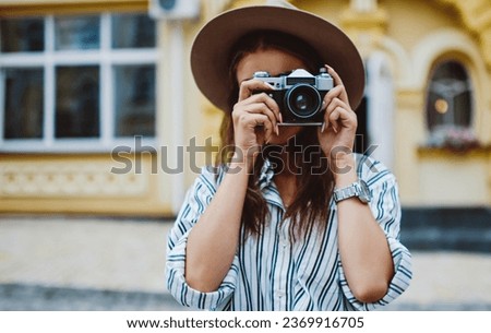young professional female photographer making image of urban settings on free time outdoors
