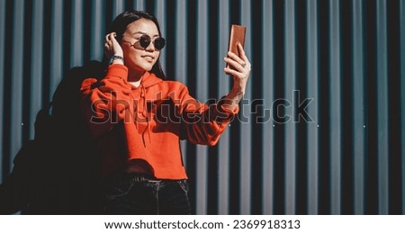  beautiful chinese hipster girl photographing on smartphone front camera