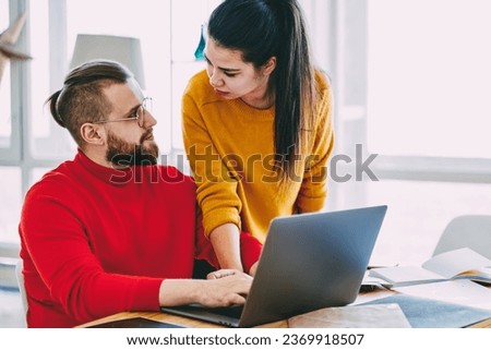 Serious young marriage discussing shopping in web store using laptop computer indoors at home