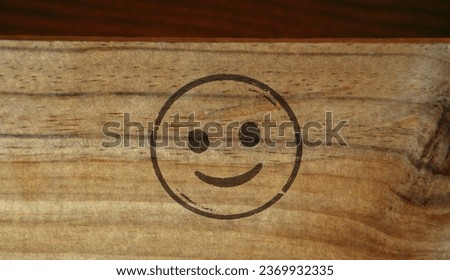 Smiley emoticon icon symbol stamp printed on wooden box. Smile emoji concept.