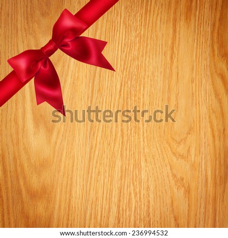 Red ribbon and bow on wooden background