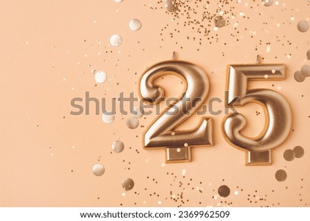 Gold candles in the form of number twenty five on peach background with confetti. 25 years anniversary celebration. Royalty-Free Stock Photo #2369962509