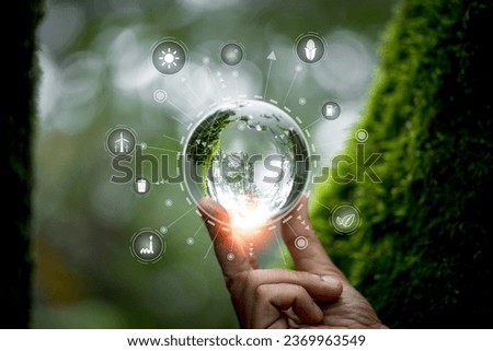 Hands protecting globe of green tree on nature background, ecology and environment. Hand holding green earth ESG icon for Environment Social and Governance, World sustainable environment concept.