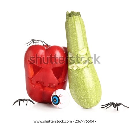 Carved bell pepper, zucchini for Halloween with eye and spiders on white background