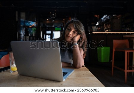 Young hardworking freelancer business woman or college student work and study online on laptop computer while sitting in cafeteria or coffee shop typing and drinking orange juice Royalty-Free Stock Photo #2369966905