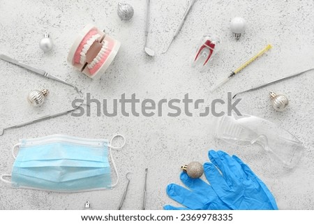 Frame made of dentist's tools with Christmas decor on grunge background