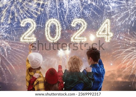 Happy new year. Family watching fireworks. Parents and kids celebrate new 2024 year. Winter holiday party. Outdoor fun. Children, mother and father with sparkler watch firework show.