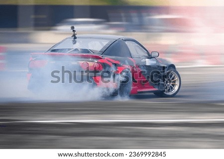 Drifting Sports sedan with modified engine and suspension action car slide faster on asphalt track speed motion blurred  with wheel tire  turning slip burn rubber smoke, Drift motor sport car racing . Royalty-Free Stock Photo #2369992845