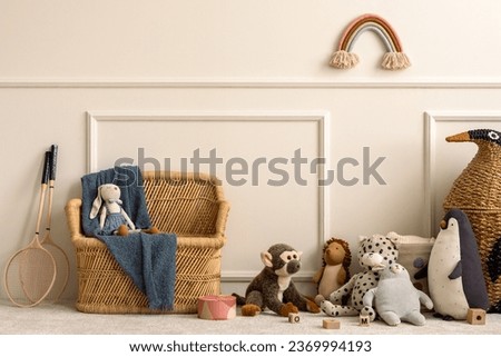 Creative composition of kids room interior with wicker basket, plush animal toys, plaid, wooden blockers, ornament on wall, beige wall with stucco and personal accessories. Home decor. Template.