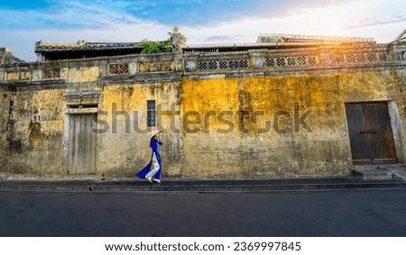 Vietnamese girls in national costumes Walk at the old town of Hoi An, Vietnam. with a beautiful and unique architecture. Royalty-Free Stock Photo #2369997845