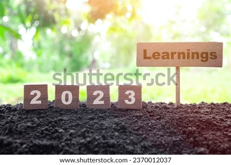 Year 2023 lessons ang learnings concept. Wooden blocks typography in natural background. Royalty-Free Stock Photo #2370012037
