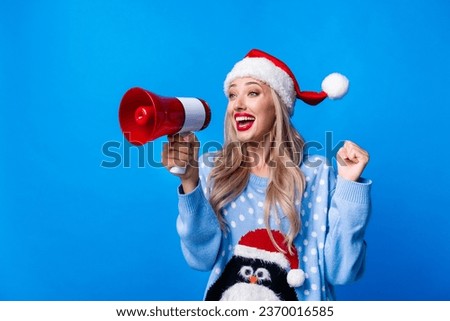 Photo portrait of lovely blonde young lady shout excited loudspeaker wear penguin sweater x-mas hat isolated on blue color background
