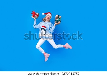 Full body cadre of jumping with two gift boxes girl invite brochure shopping mall new year atmosphere isolated on blue color background