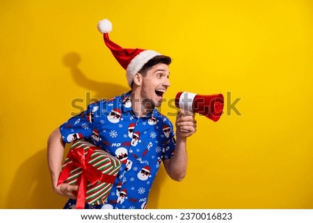 Profile portrait of crazy guy hold giftbox talk loudspeaker empty space x-mas ad isolated on yellow color background