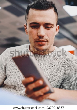 Hipster guy reading email with notification on digital cellular using 4G internet connection