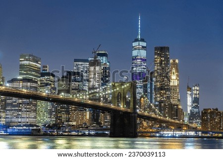 Brooklyn Bridge and panoramic night view of downtown Manhattan after sunset in New York City, USA