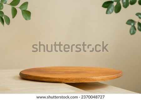 Minimal wood plate podium table top blurred green leaf plant on beige space nature background.Beauty cosmetic natural product display.