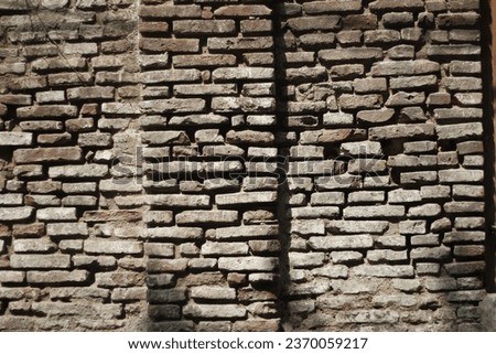 Picture of the old walls, made of red bricks that are hundreds years old during the sunny day, taken with medium shot.
