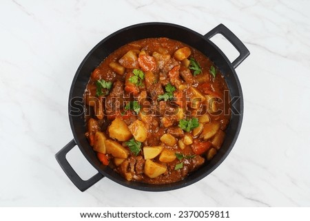 Traditional homemade Hungarian beef meat stew and soup  - Goulash with potatoes, carrots , tomatoes, bell pepper  Royalty-Free Stock Photo #2370059811